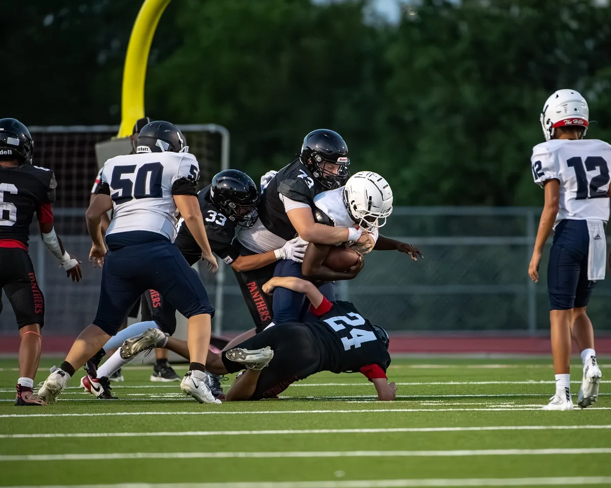 Ben Payne (#73) driving a defender back with strong hand placement during a game against Richland