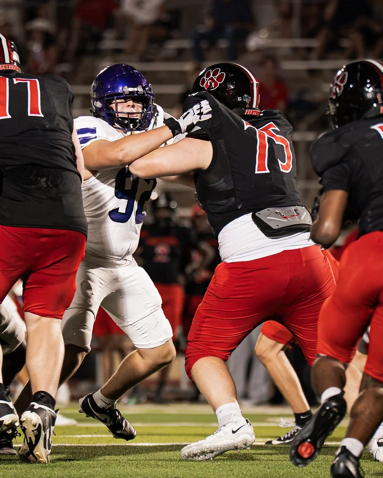 Ben Payne (#75) engaged in a pass block during his varsity debut against Anna