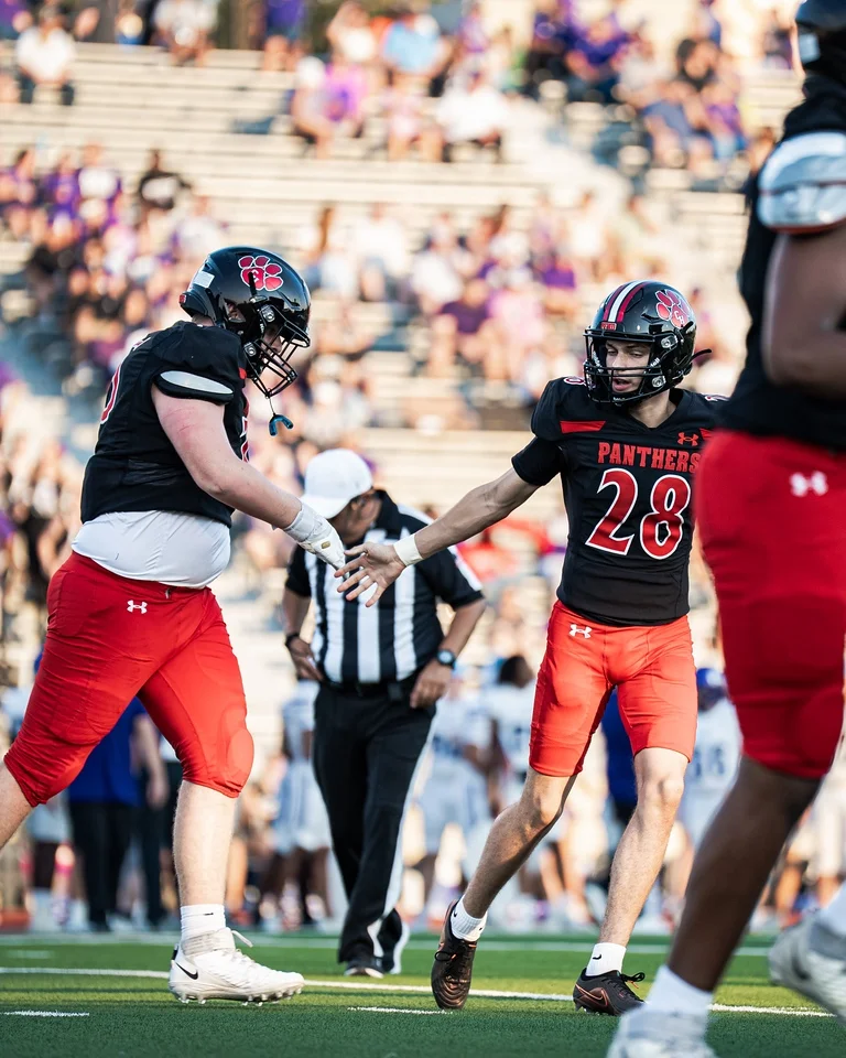 Ben Payne (#75) celebrating with a teammate during his varsity debut against Anna