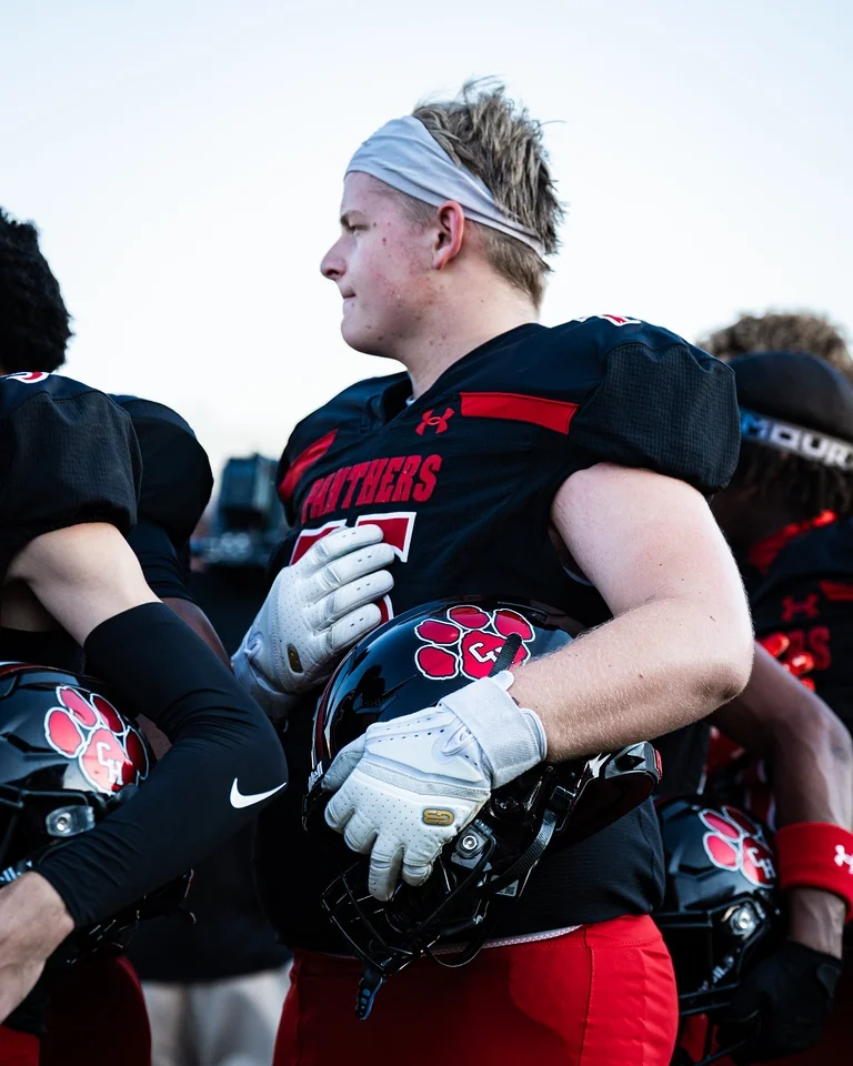 Ben Payne (#75) with teammates on the sideline during his varsity debut against Anna
